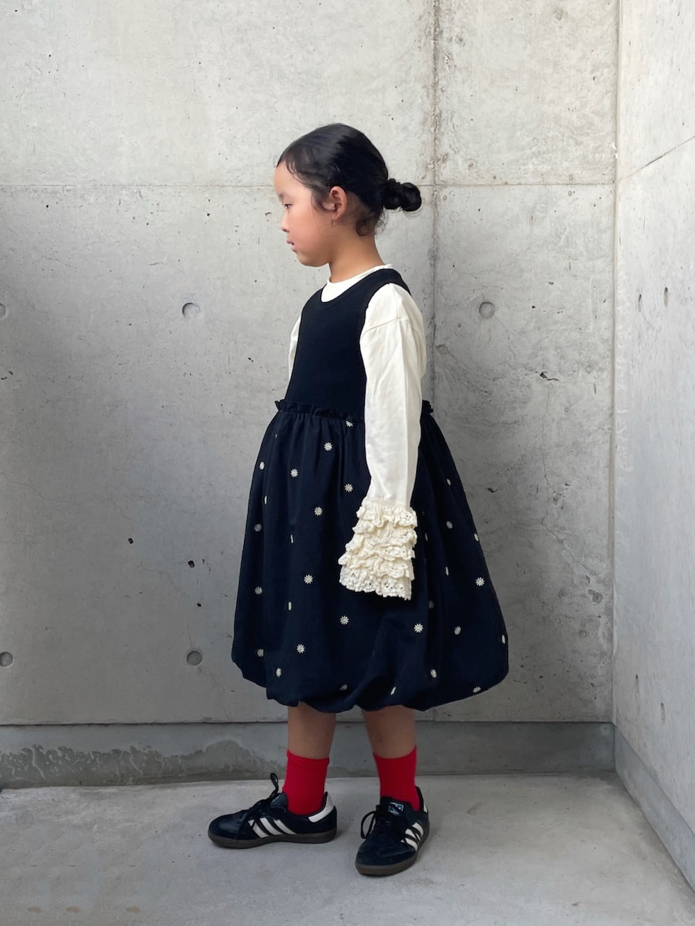 ブラック系のワンピース、ブラック系のスニーカー、ホワイト系のTシャツ/カットソーを着用したキッズの秋コーディネートの5枚目の写真