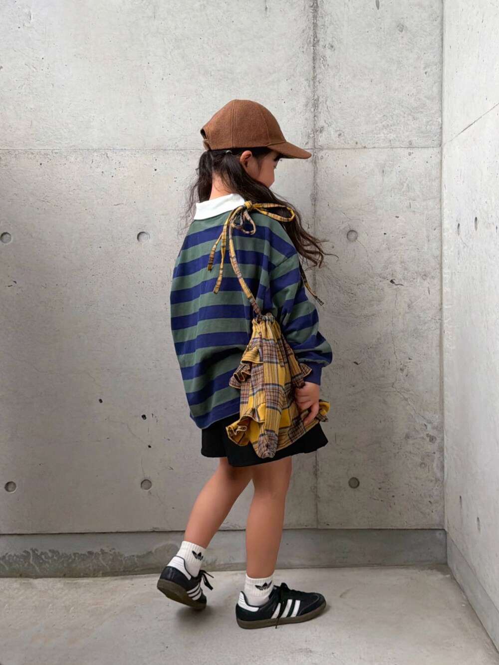 ブラック系のスニーカー、グリーン系のポロシャツ、イエロー系のバックパック/リュックを着用したキッズの秋コーディネートの2枚目の写真