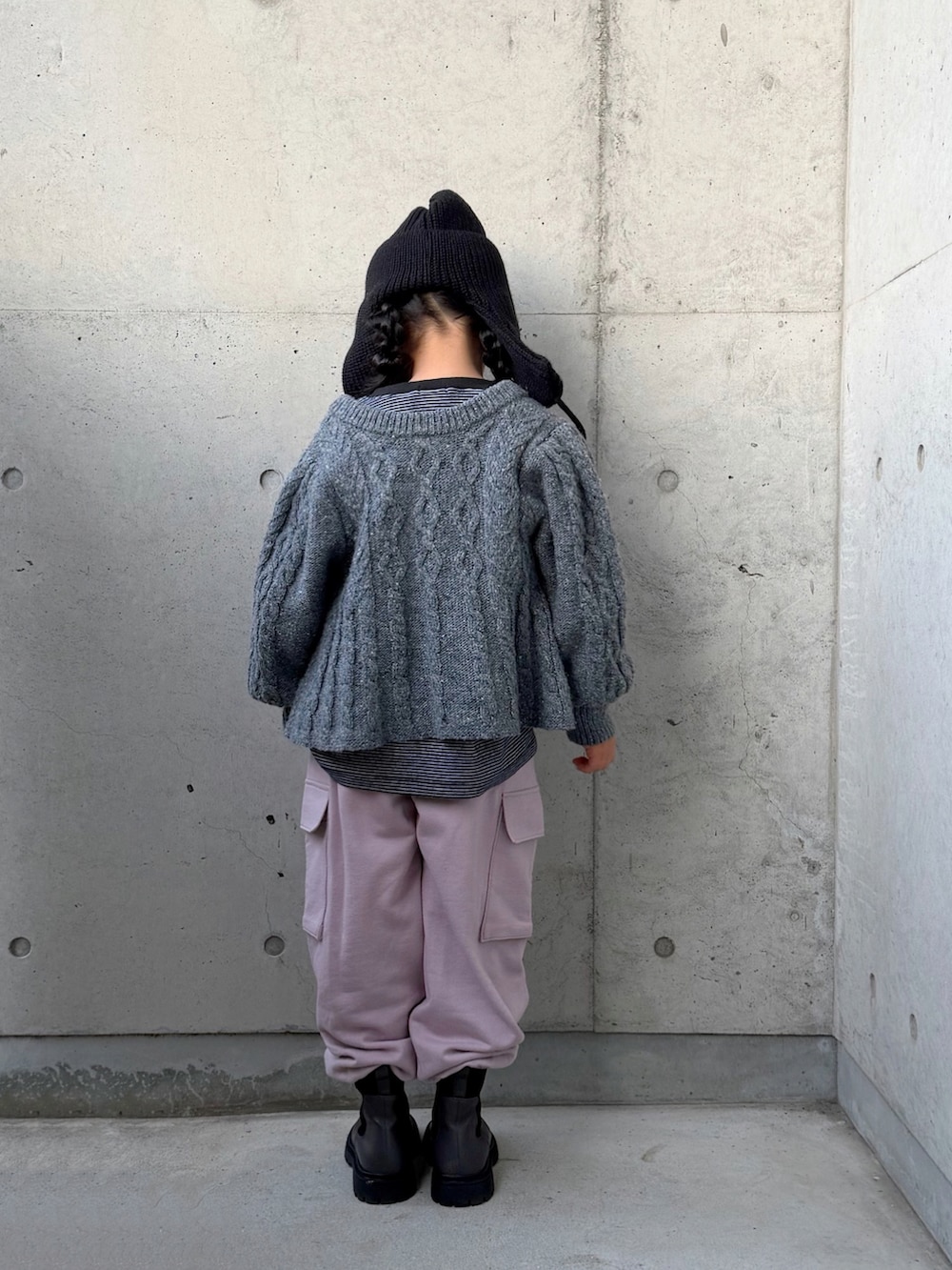 ピンク系のカーゴパンツ、グレー系のブーツ、ブラック系のTシャツ/カットソーを着用したキッズの冬コーディネートの3枚目の写真