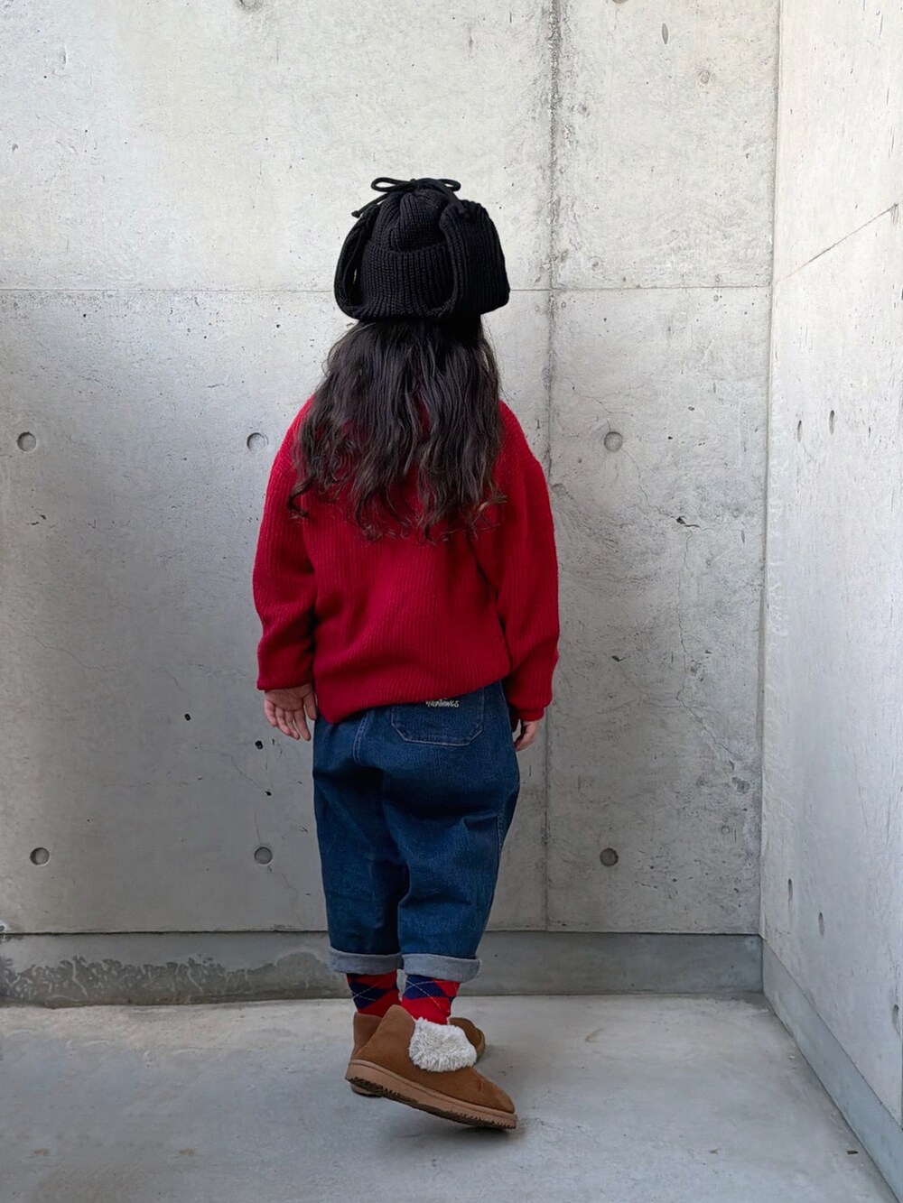 ホワイト系のニット/セーター、ブラウン系のブーツ、ブルー系のデニムパンツを着用したキッズの秋コーディネートの3枚目の写真