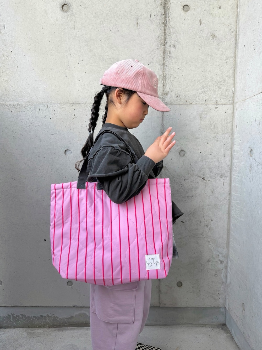 グレー系のTシャツ/カットソー、ピンク系のカーゴパンツ、ブラック系のスカートを着用したキッズの冬コーディネートの4枚目の写真