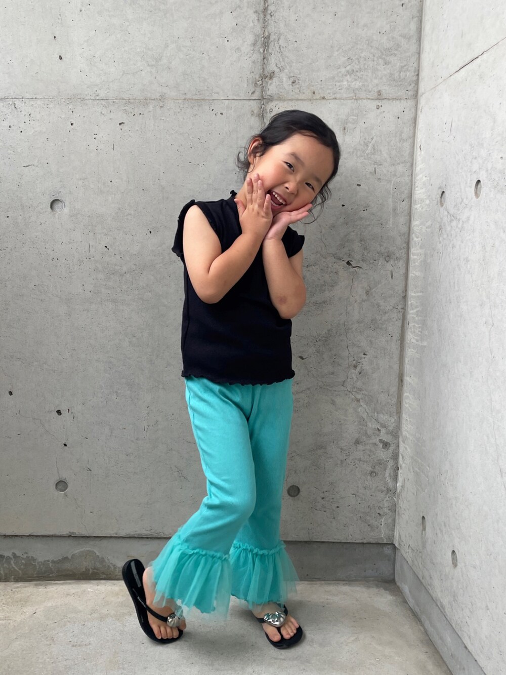 ブラック系のサンダル、ブラック系のトップス、ブルー系のパンツを着用したキッズの春コーディネートの2枚目の写真