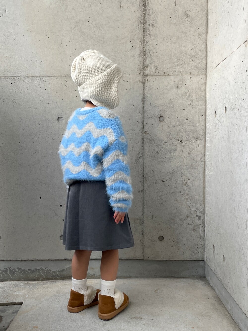 グレー系のスーツセット、ブルー系のニット/セーター、ブラウン系のブーツを着用したキッズの冬コーディネートの3枚目の写真