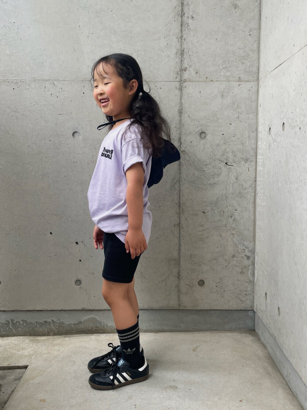 ブラック系のスニーカー、ブラック系のその他パンツ、パープル系のTシャツ/カットソーを着用したキッズの春コーディネートの2枚目の写真