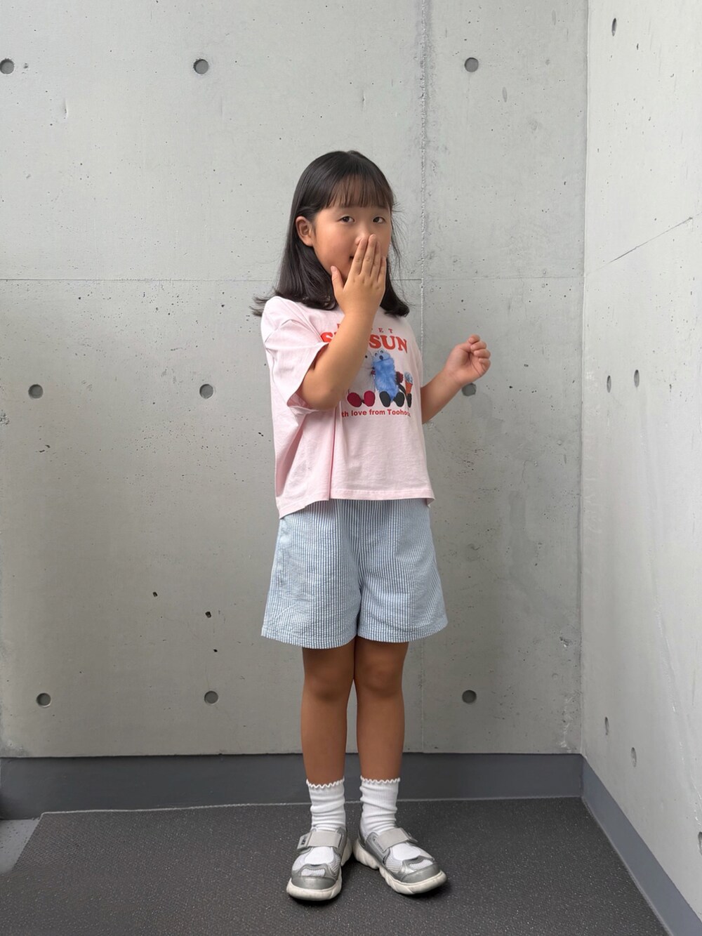 シルバー系のスニーカー、ピンク系のTシャツ/カットソー、ブルー系のパンツを着用したキッズの秋コーディネートの3枚目の写真