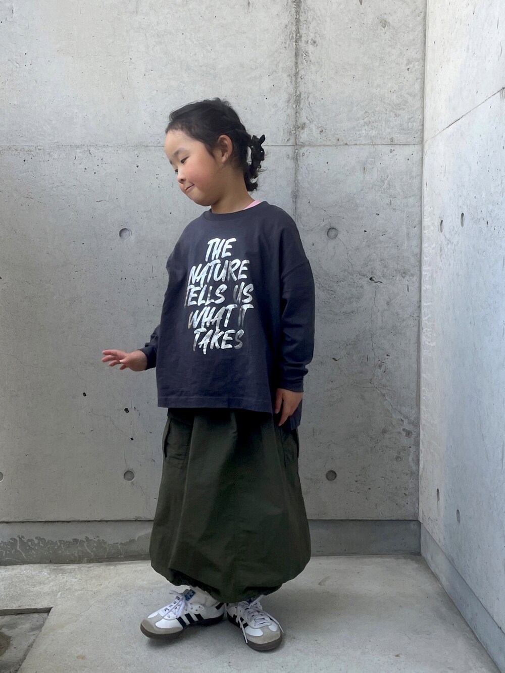 ホワイト系のスニーカー、グリーン系のスカート、グレー系のTシャツ/カットソーを着用したキッズの春コーディネートの4枚目の写真