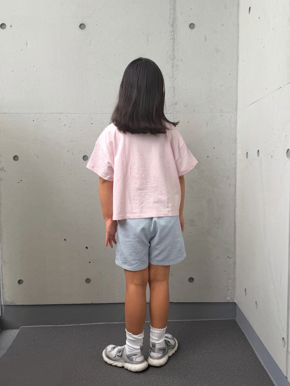 シルバー系のスニーカー、ピンク系のTシャツ/カットソー、ブルー系のパンツを着用したキッズの秋コーディネートの2枚目の写真