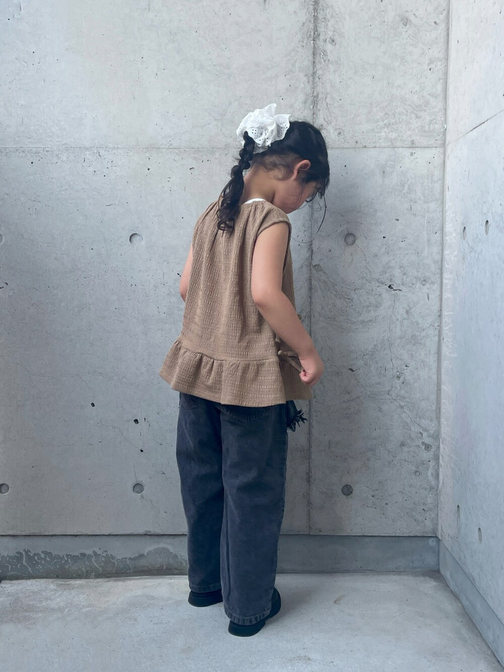 ブラウン系のパンツドレス、ブラック系のブーツ、ブラック系のパンツを着用したキッズの夏コーディネートの3枚目の写真