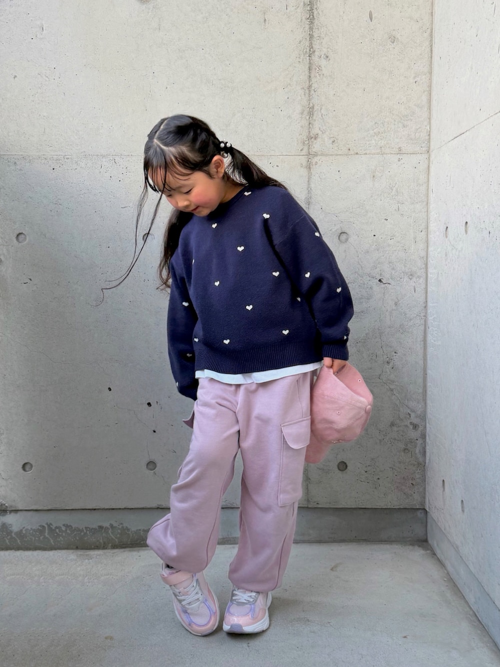 ピンク系のカーゴパンツ、ピンク系のスニーカー、ブルー系のニット/セーターを着用したキッズの冬コーディネートの5枚目の写真