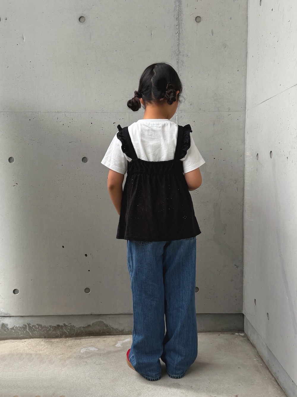 ブラック系のセットアップ、レッド系のスニーカー、ブルー系のデニムパンツを着用したキッズの夏コーディネートの4枚目の写真