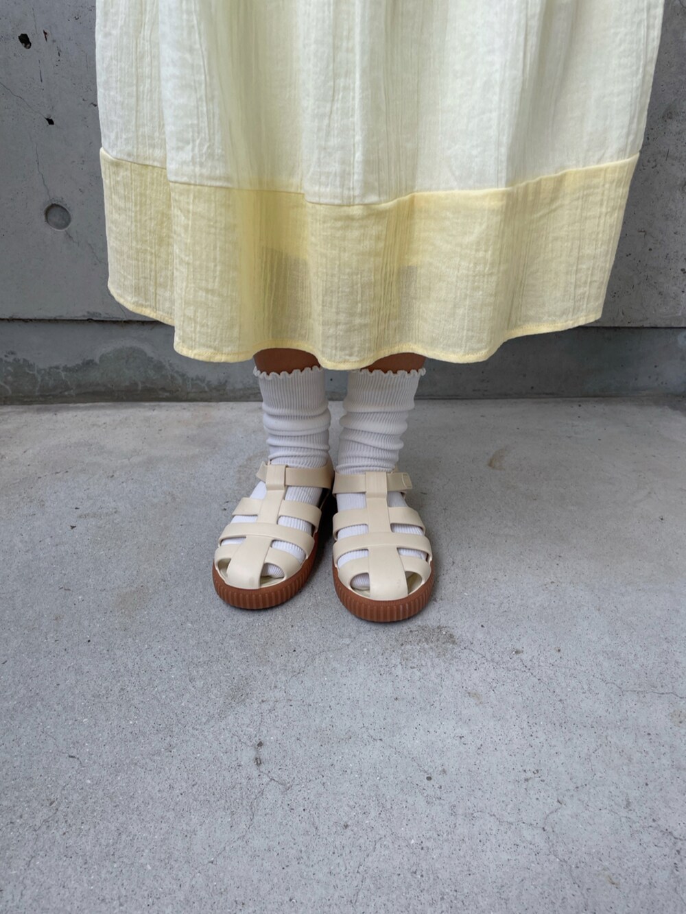 ホワイト系のサンダル、ホワイト系のTシャツ/カットソー、イエロー系のワンピースを着用したキッズの夏コーディネートの5枚目の写真