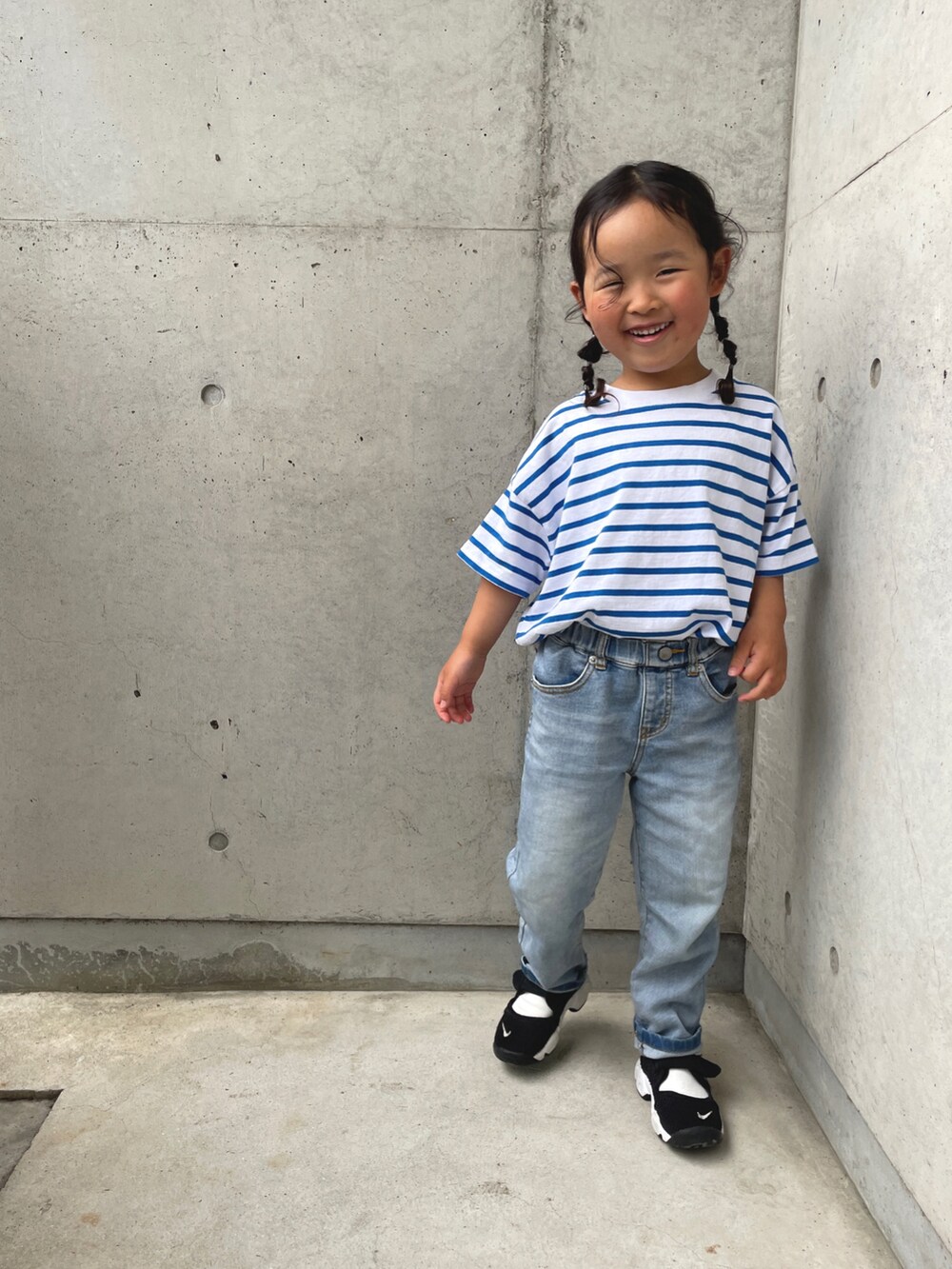 ブルー系のTシャツ/カットソー、ブラック系のスニーカー、ブルー系のデニムパンツを着用したキッズの春コーディネートの4枚目の写真