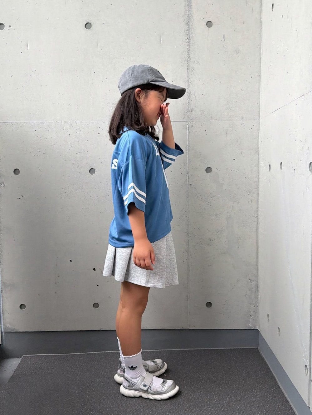 グレー系のスニーカー、ブルー系のTシャツ/カットソー、グレー系のスカートを着用したキッズの秋コーディネートの5枚目の写真