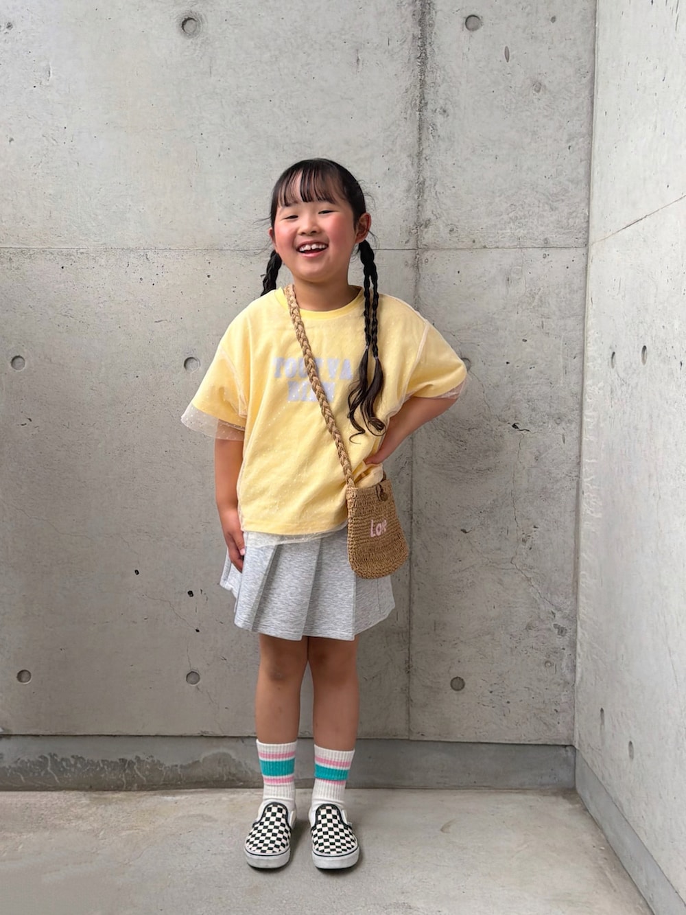 イエロー系のTシャツ/カットソー、ブラック系のスリッポン、グレー系のスカートを着用したキッズの春コーディネートの3枚目の写真