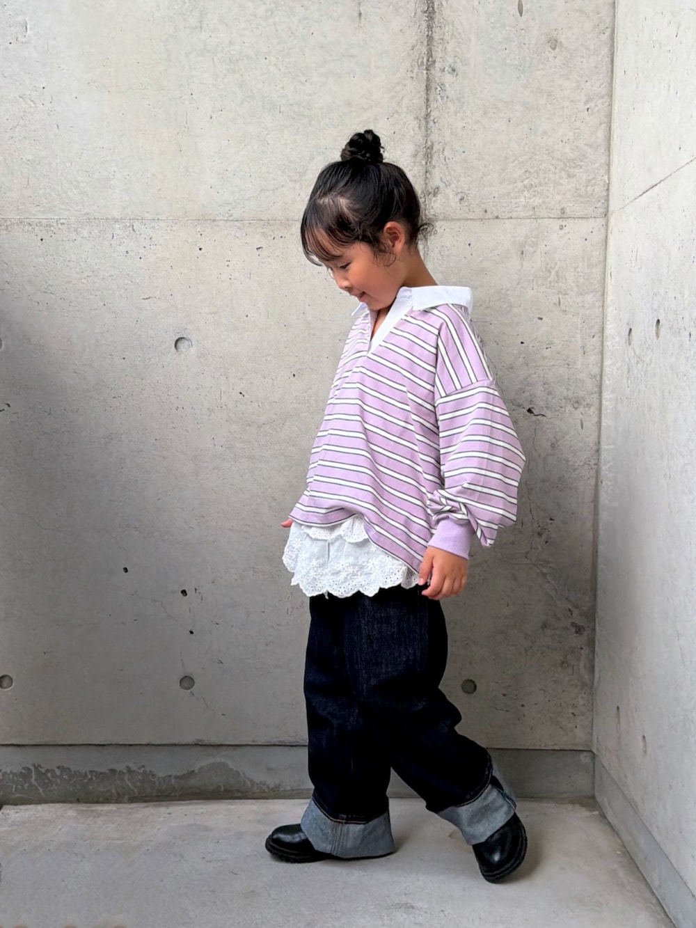 パープル系のポロシャツ、ブラック系のブーツ、ホワイト系のトップスを着用したキッズの秋コーディネートの3枚目の写真