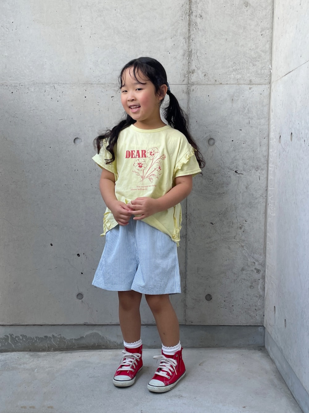 レッド系のスニーカー、ベージュ系のTシャツ/カットソー、ブルー系のパンツを着用したキッズの秋コーディネートの5枚目の写真