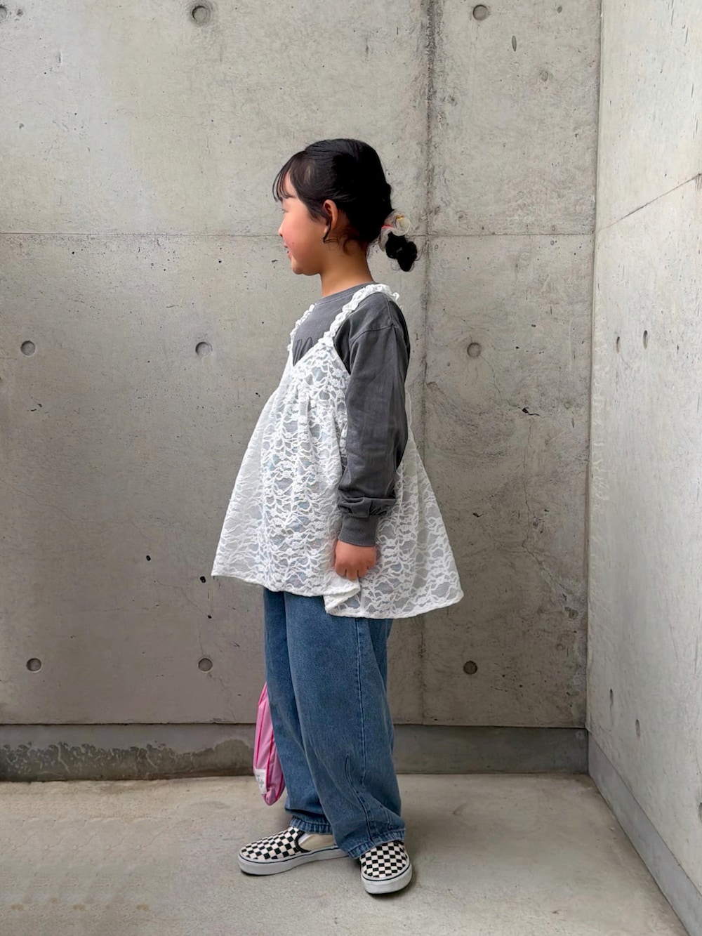 ピンク系のトートバッグ、ブラック系のスリッポン、ホワイト系のトップスを着用したキッズの春コーディネートの3枚目の写真