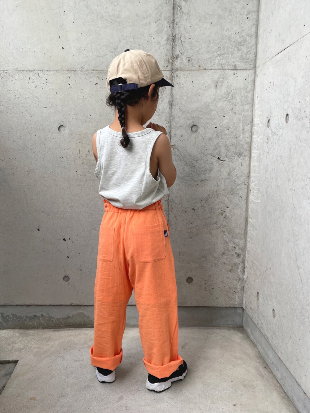 グレー系のトップス、ブラック系のサンダル、オレンジ系のその他パンツを着用したキッズの夏コーディネートの3枚目の写真