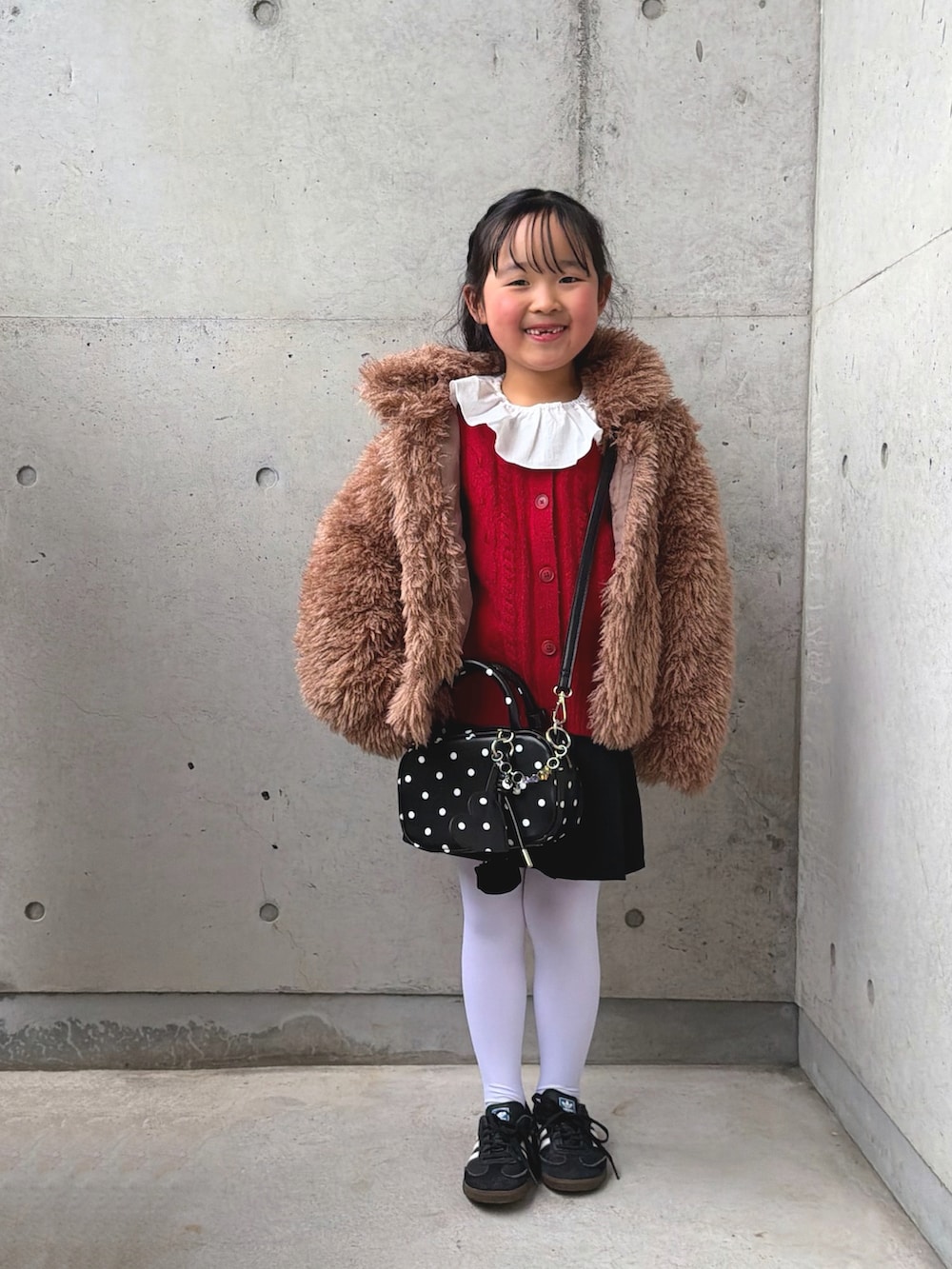 ブラウン系のブルゾン、その他のボストンバッグ、ホワイト系のシャツ/ブラウスを着用したキッズの冬コーディネートの5枚目の写真