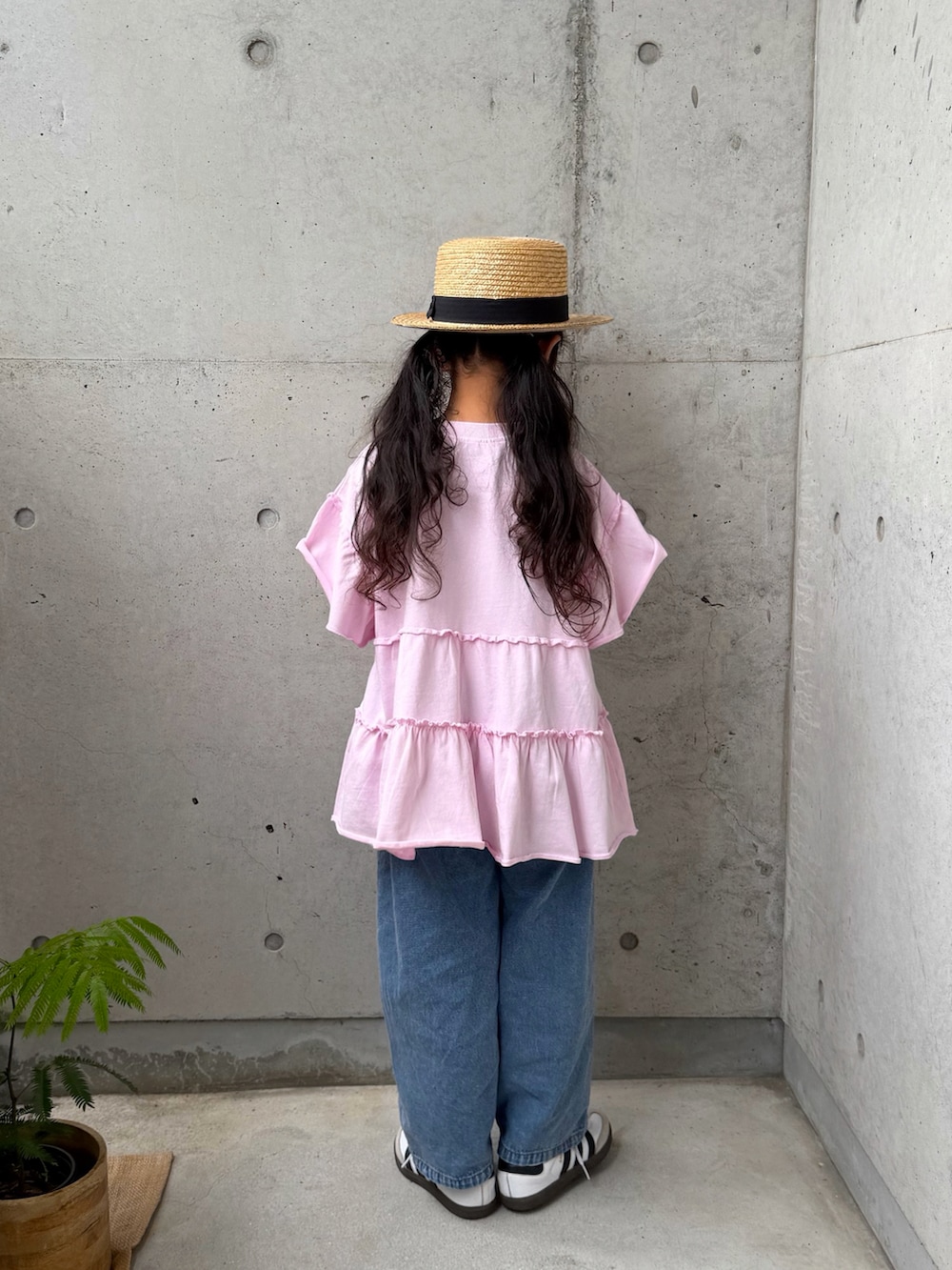 ピンク系のTシャツ/カットソー、ホワイト系のスニーカー、ブルー系のパンツを着用したキッズの春コーディネートの3枚目の写真