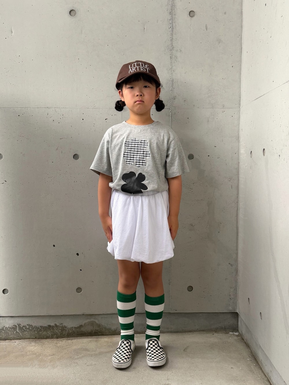 ブラック系のスリッポン、グレー系のTシャツ/カットソー、ホワイト系のスカートを着用したキッズの夏コーディネートの4枚目の写真