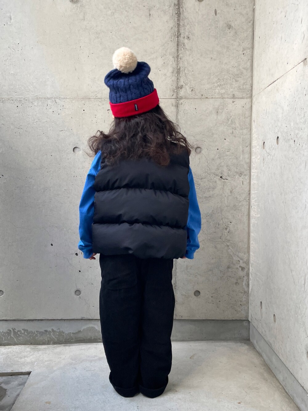 ブラック系のダウンベスト、ブルー系のTシャツ/カットソー、ブラック系のサロペット/オーバーオールを着用したキッズの冬コーディネートの5枚目の写真