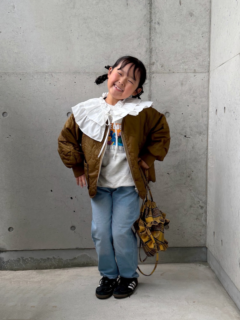 ブラック系のスニーカー、ブルー系のデニムパンツ、イエロー系のバックパック/リュックを着用したキッズの秋コーディネートの5枚目の写真