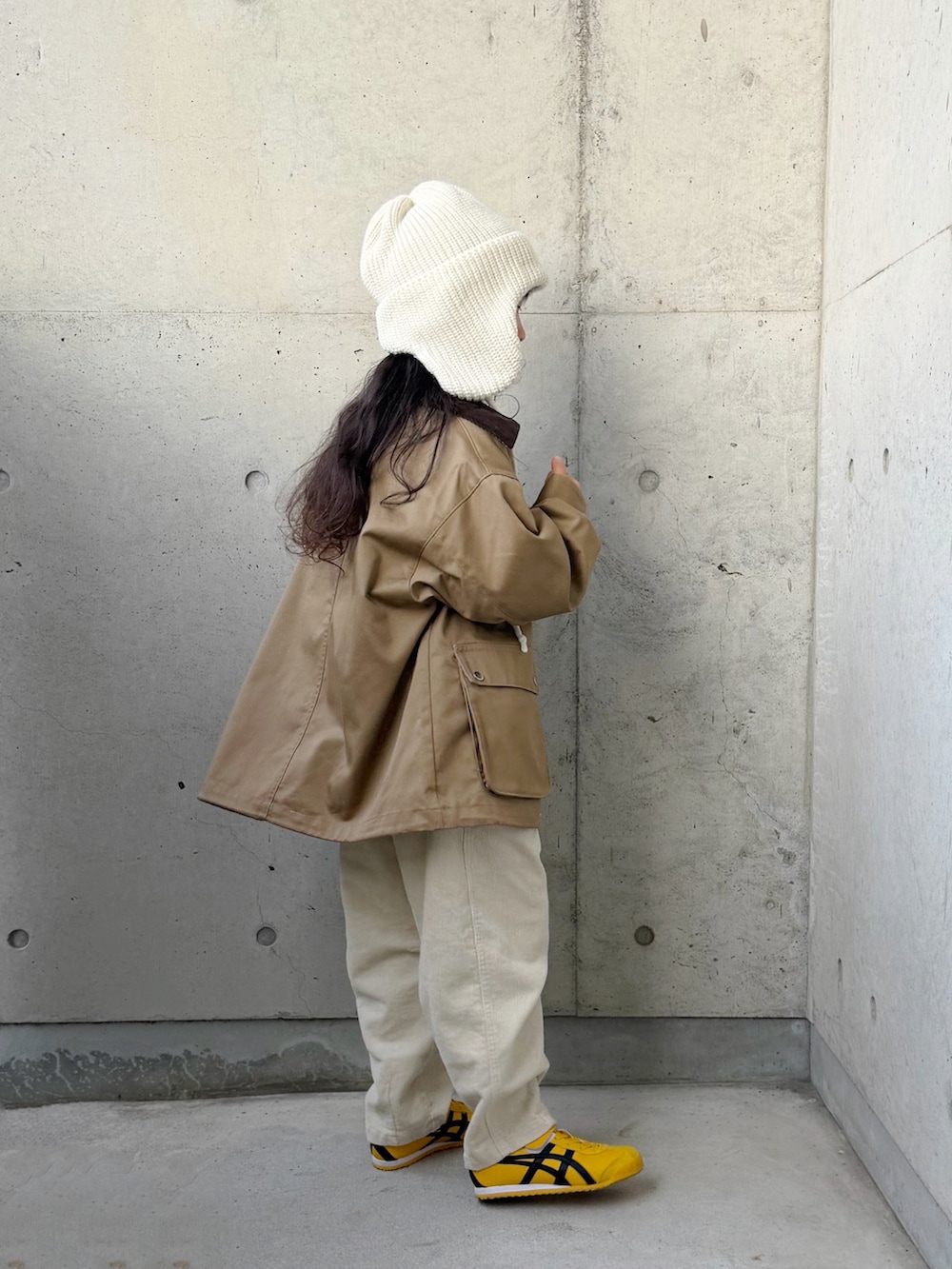 ベージュ系のミリタリージャケット、ベージュ系のその他パンツ、イエロー系のスニーカーを着用したキッズの秋コーディネートの5枚目の写真