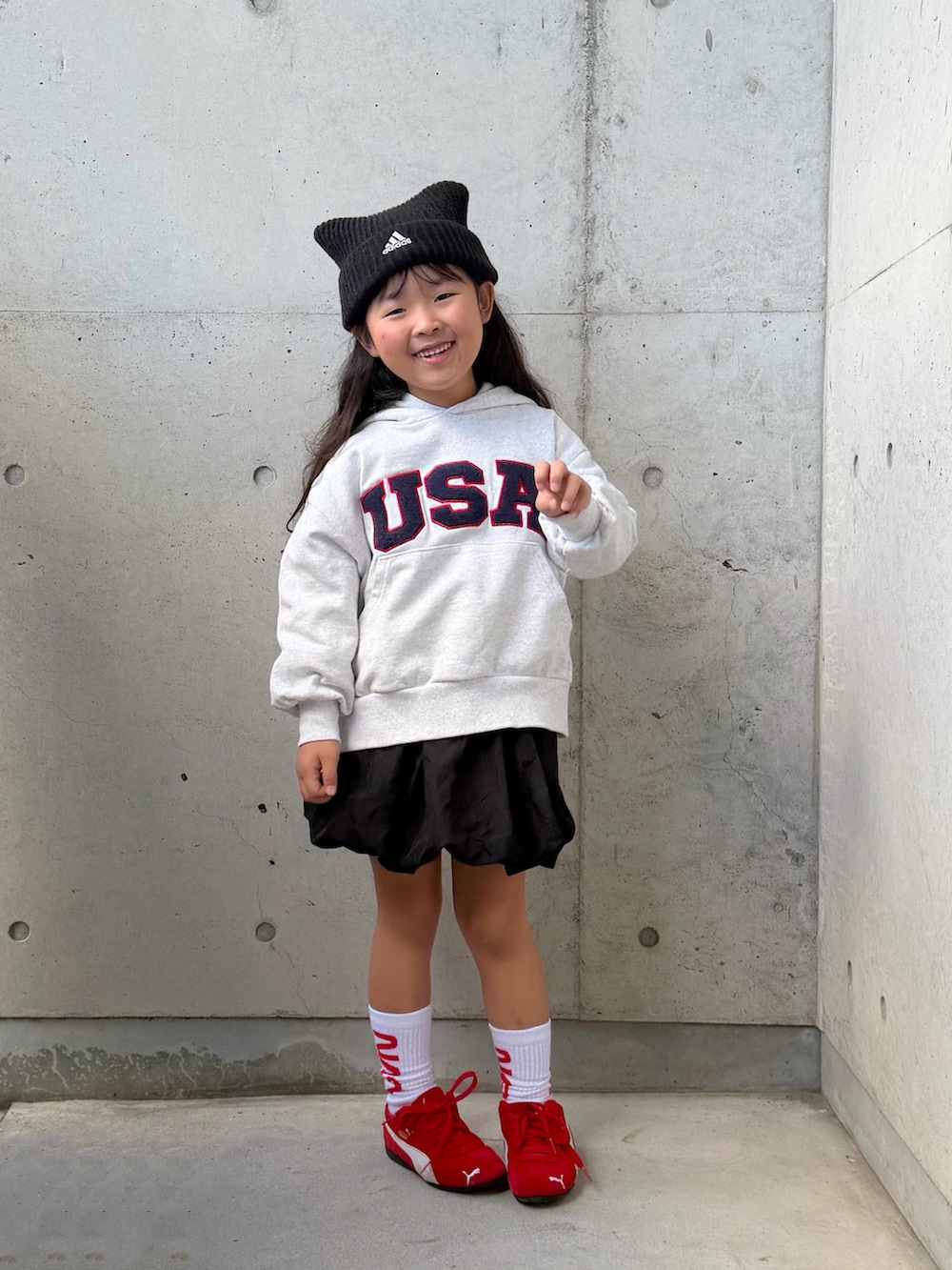 グレー系のスウェット、ブラック系のスカート、レッド系のスニーカーを着用したキッズの秋コーディネートの5枚目の写真