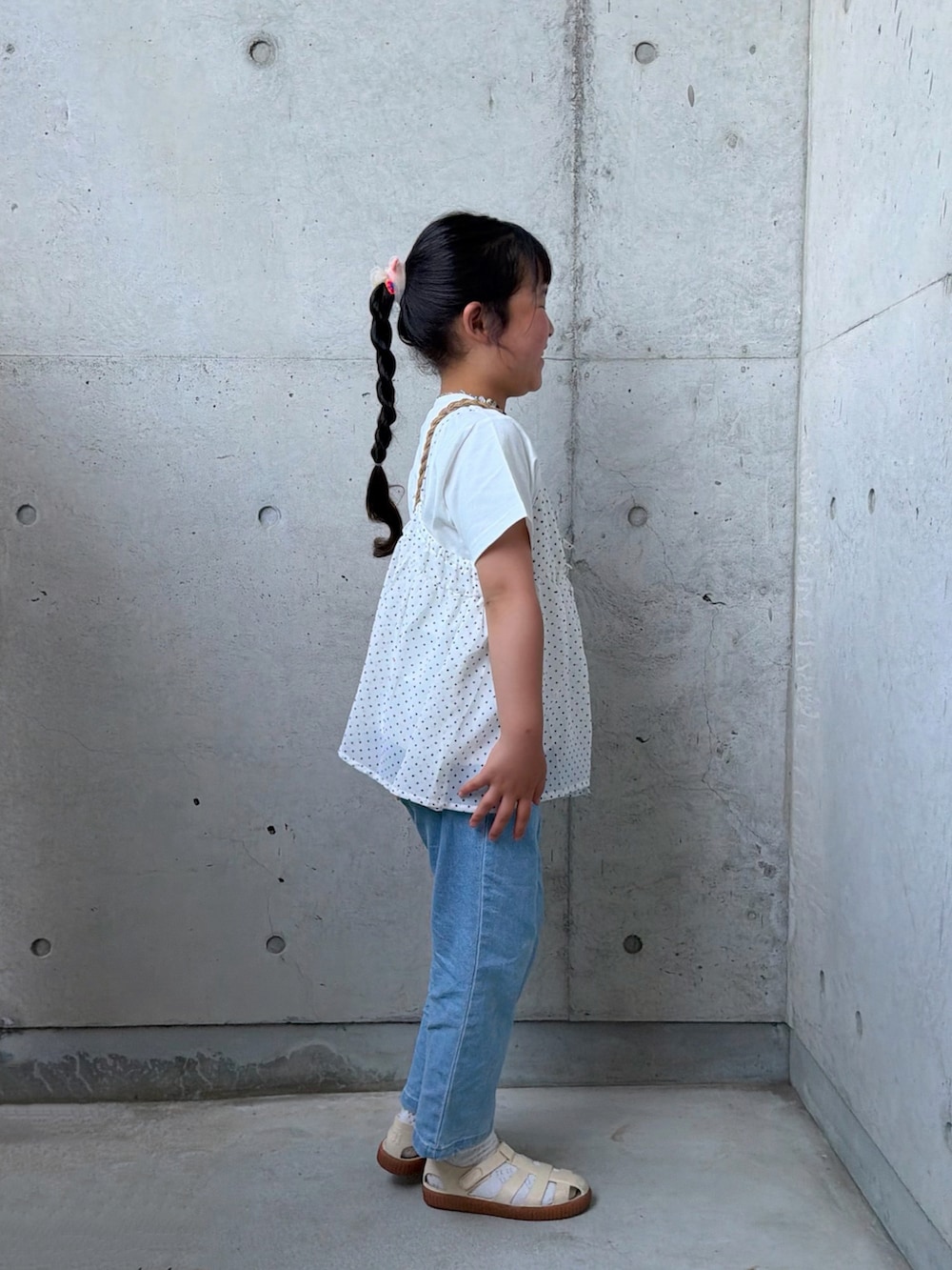 ブルー系のデニムパンツ、ホワイト系のTシャツ/カットソー、ベージュ系のショルダーバッグを着用したキッズの春コーディネートの5枚目の写真