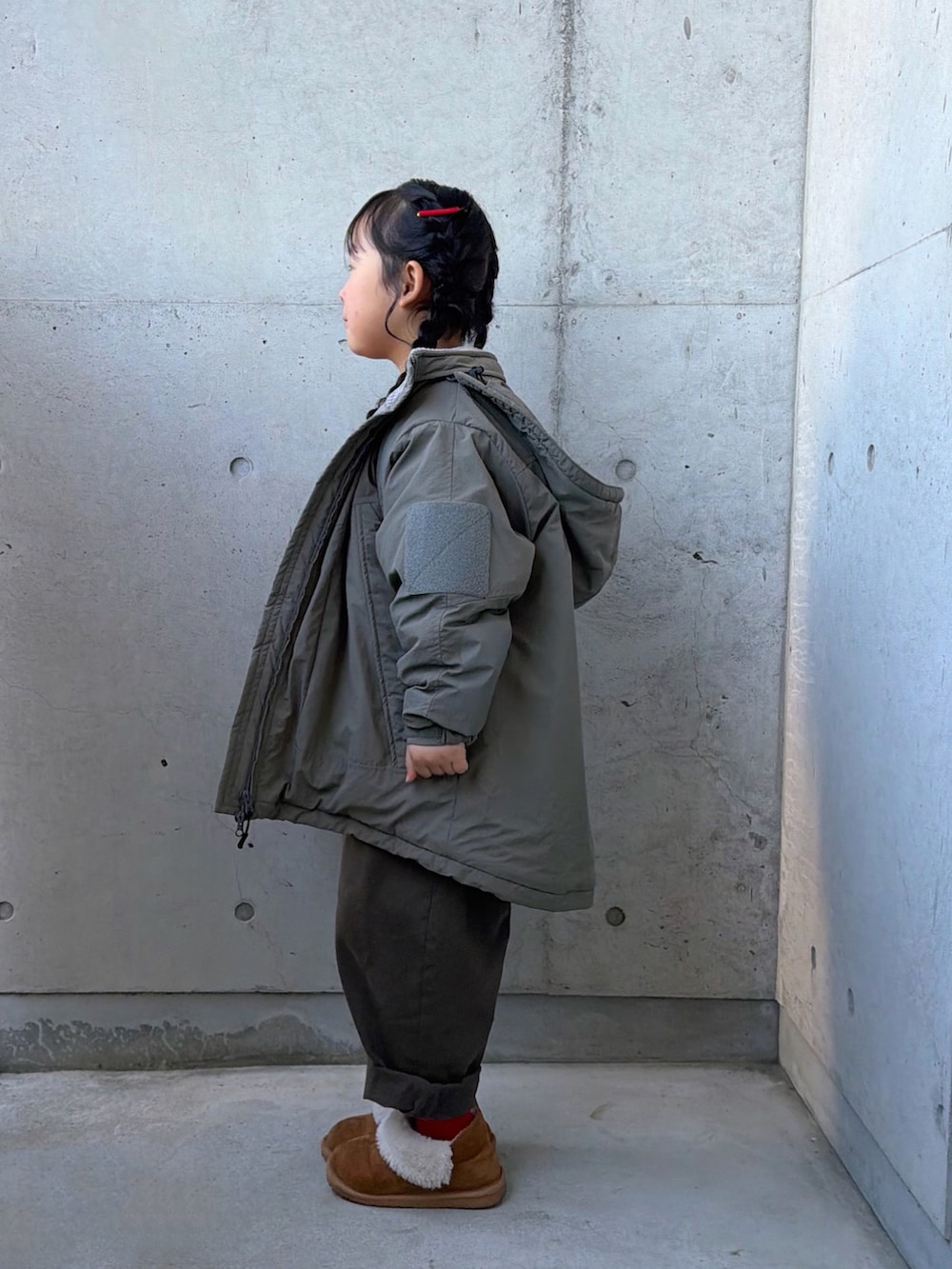 グレー系のサロペット/オーバーオール、ブラウン系のブーツ、ブラック系のTシャツ/カットソーを着用したキッズの冬コーディネートの2枚目の写真