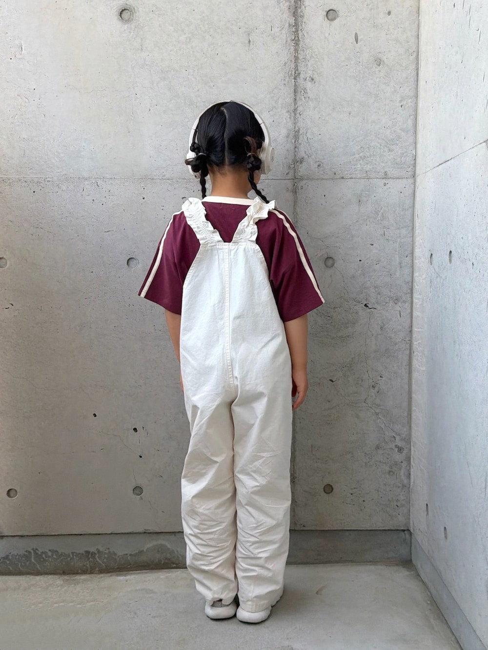 ホワイト系のサロペット/オーバーオール、レッド系のTシャツ/カットソー、シルバー系のスニーカーを着用したキッズの春コーディネートの3枚目の写真