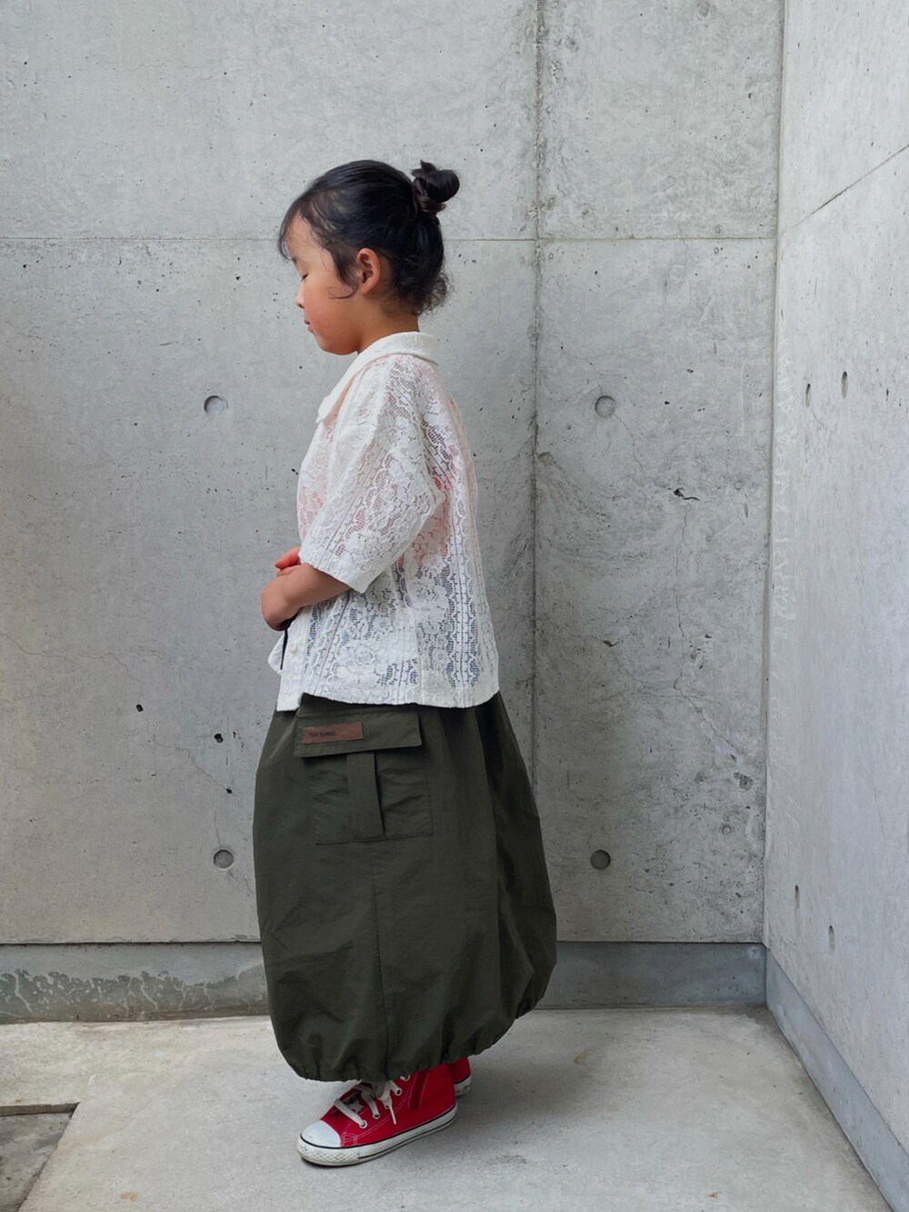 ホワイト系のシャツ/ブラウス、オレンジ系のタンクトップ、グリーン系のスカートを着用したキッズの春コーディネートの4枚目の写真