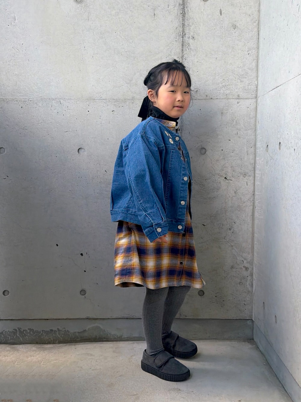 イエロー系のワンピース、グレー系のその他シューズ、ブラック系のニット/セーターを着用したキッズの冬コーディネートの4枚目の写真