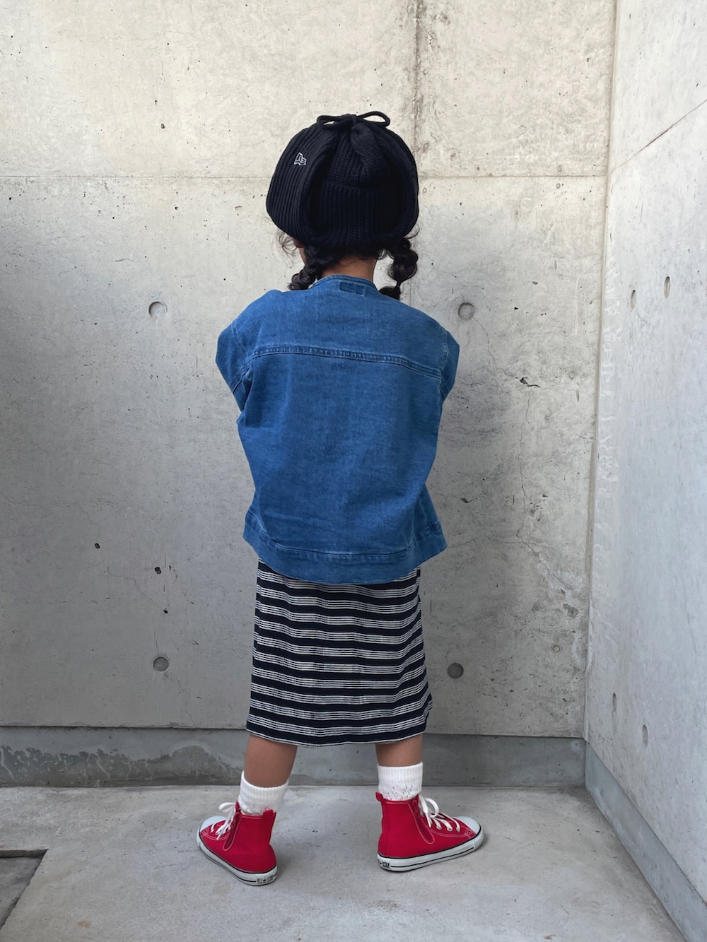 ブルー系のデニムジャケット、ブラック系のワンピース、レッド系のスニーカーを着用したキッズの秋コーディネートの5枚目の写真