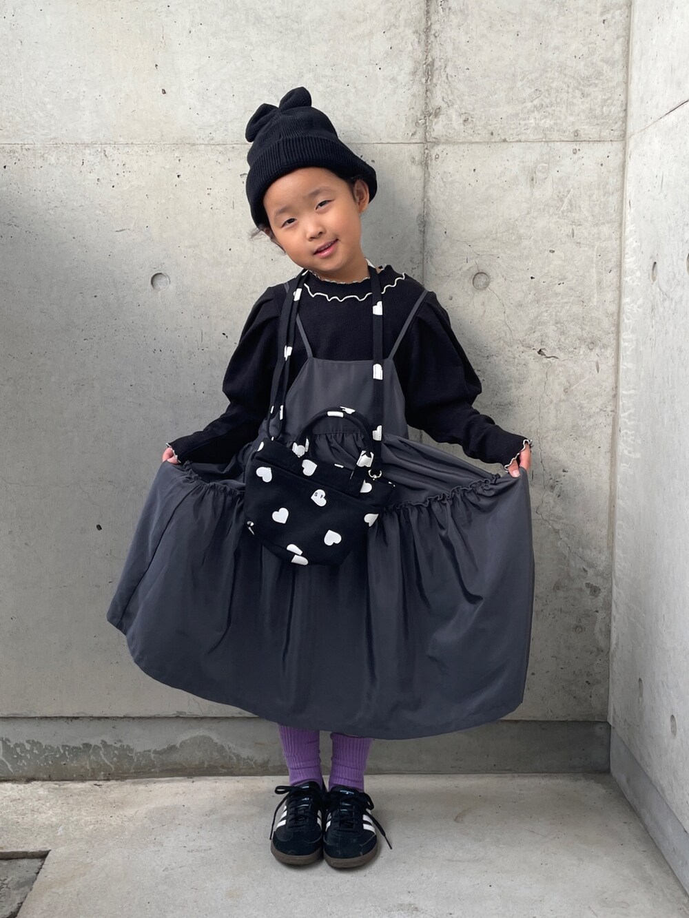 ブラック系のショルダーバッグ、ブラック系のTシャツ/カットソー、グレー系のワンピースを着用したキッズの秋コーディネートの4枚目の写真