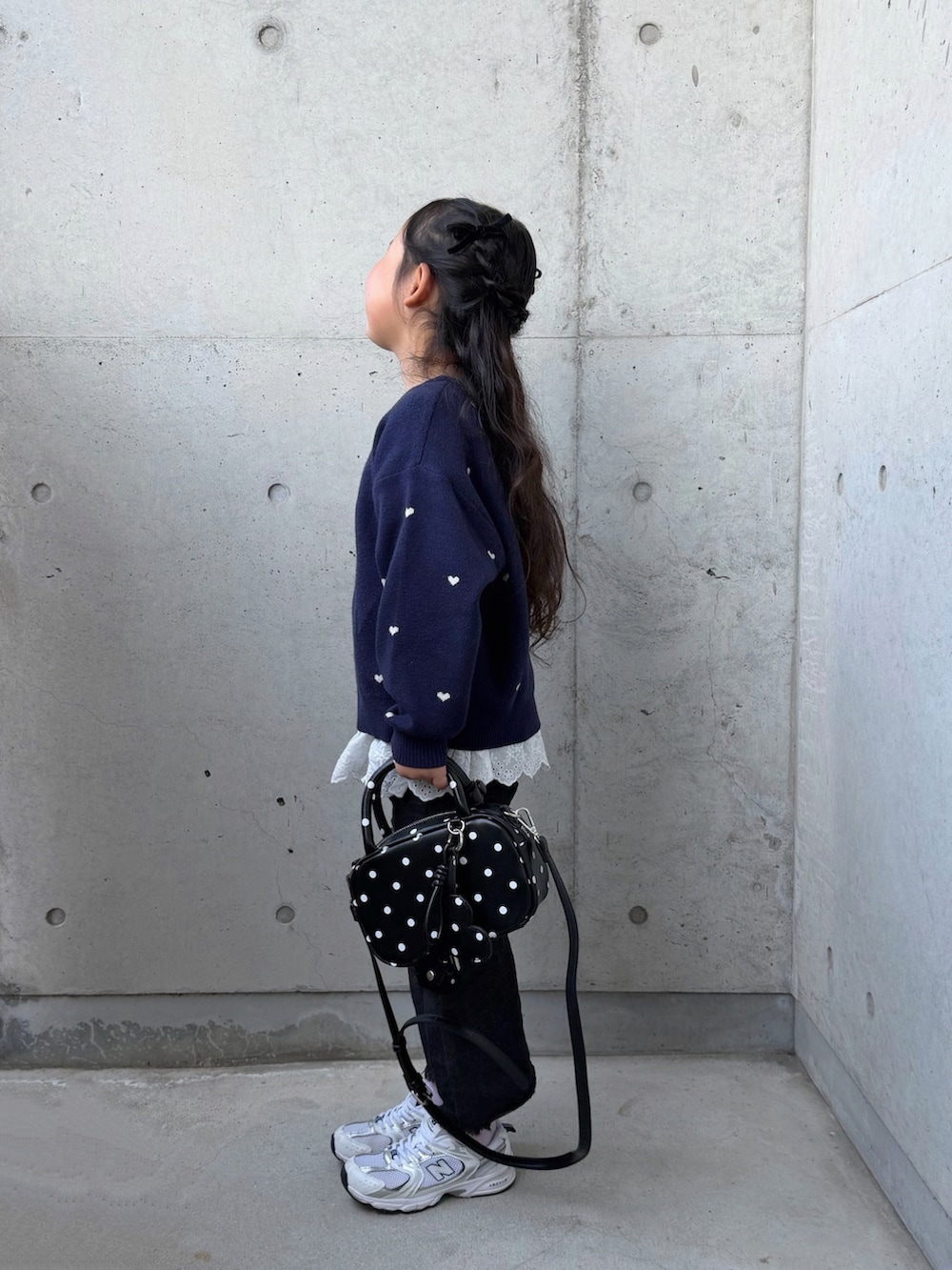 その他のボストンバッグ、ホワイト系のスニーカー、ブルー系のニット/セーターを着用したキッズの春コーディネートの2枚目の写真
