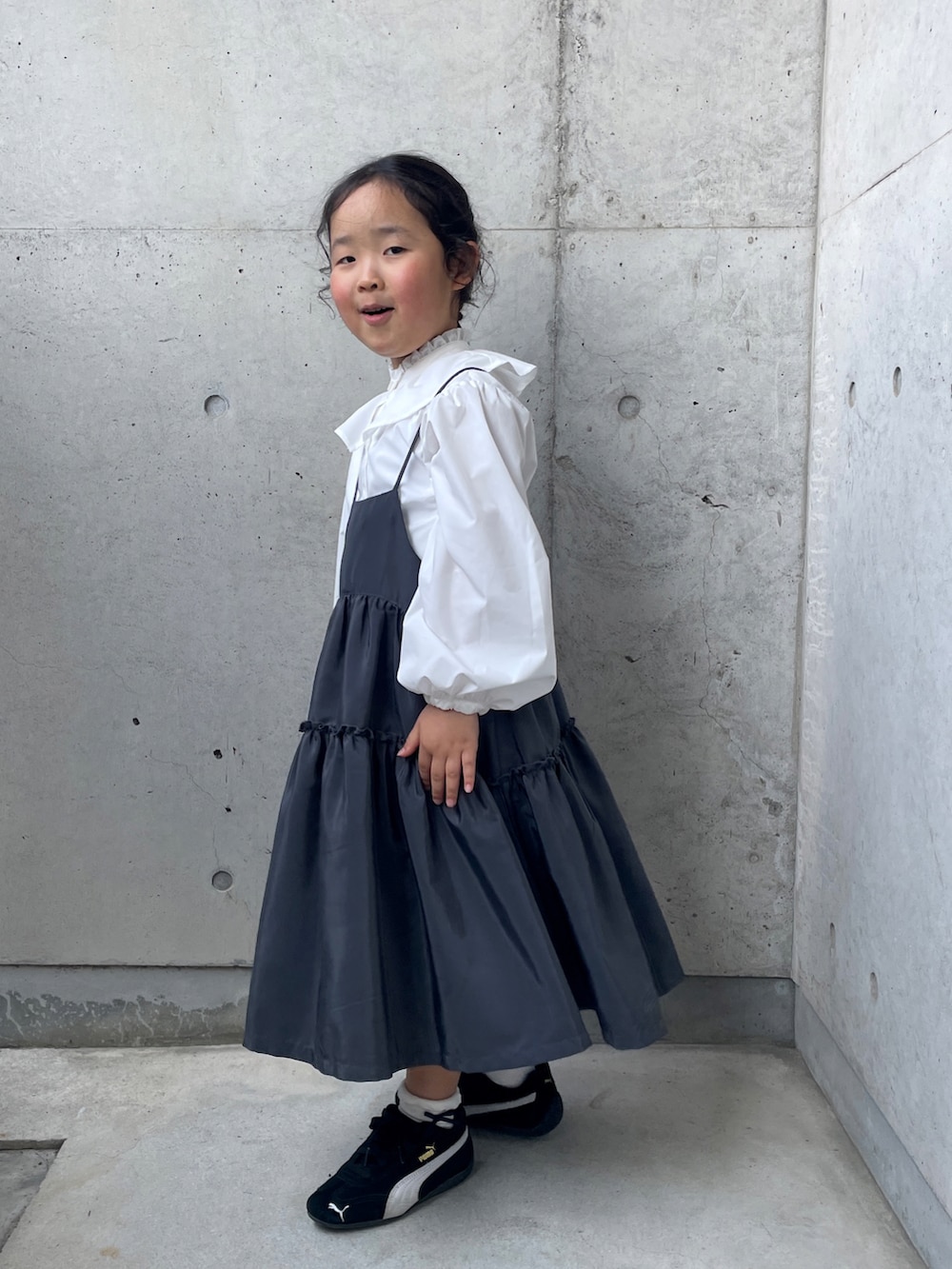 ホワイト系のシャツ/ブラウス、グレー系のワンピース、ブラック系のスニーカーを着用したキッズの春コーディネートの2枚目の写真