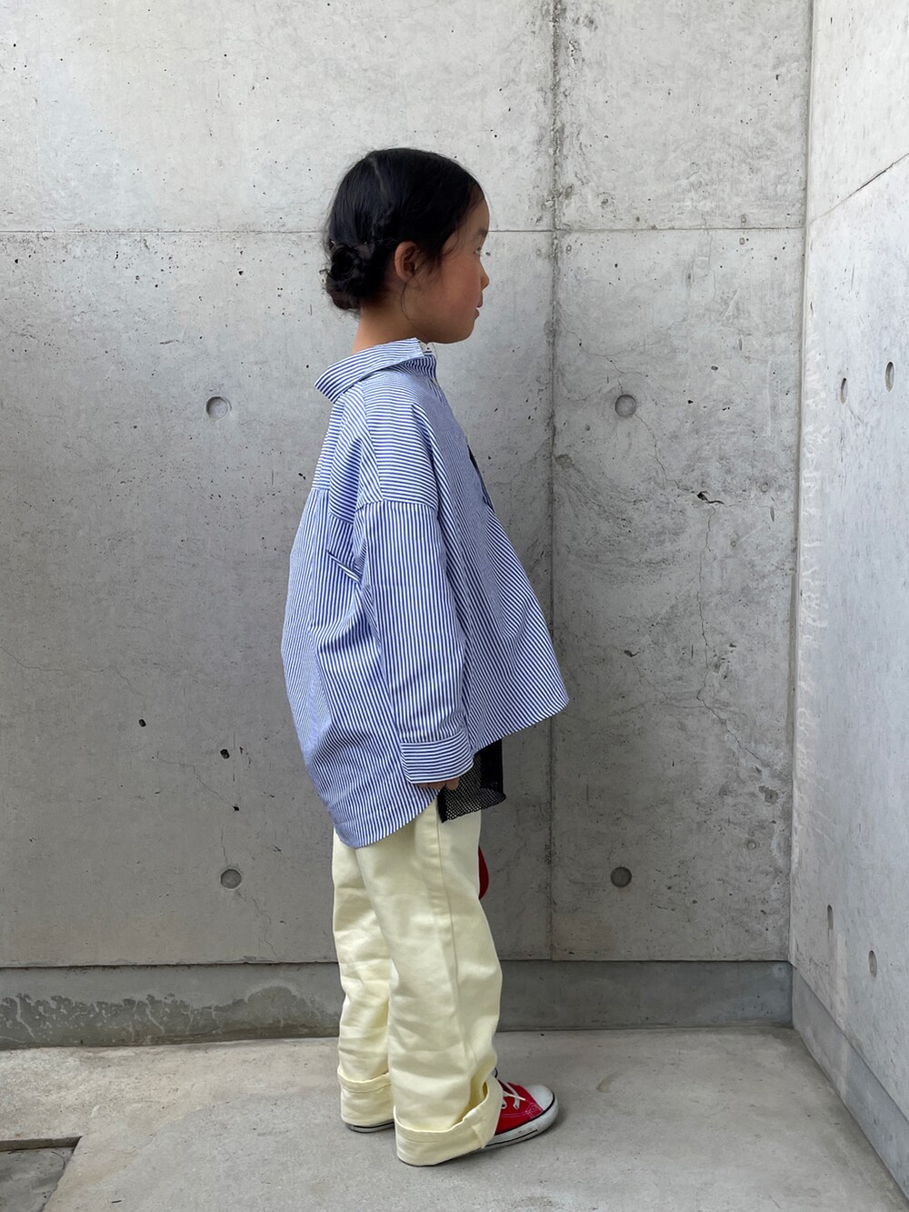 イエロー系のその他パンツ、レッド系のスニーカー、ブラック系のTシャツ/カットソーを着用したキッズの春コーディネートの5枚目の写真