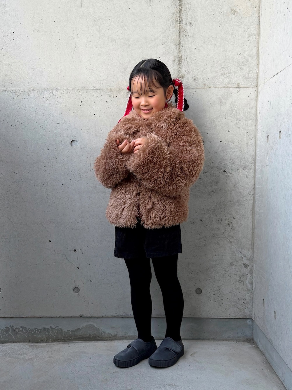 レッド系のニット/セーター、ブラック系のその他パンツ、ブラウン系のブルゾンを着用したキッズの冬コーディネートの3枚目の写真