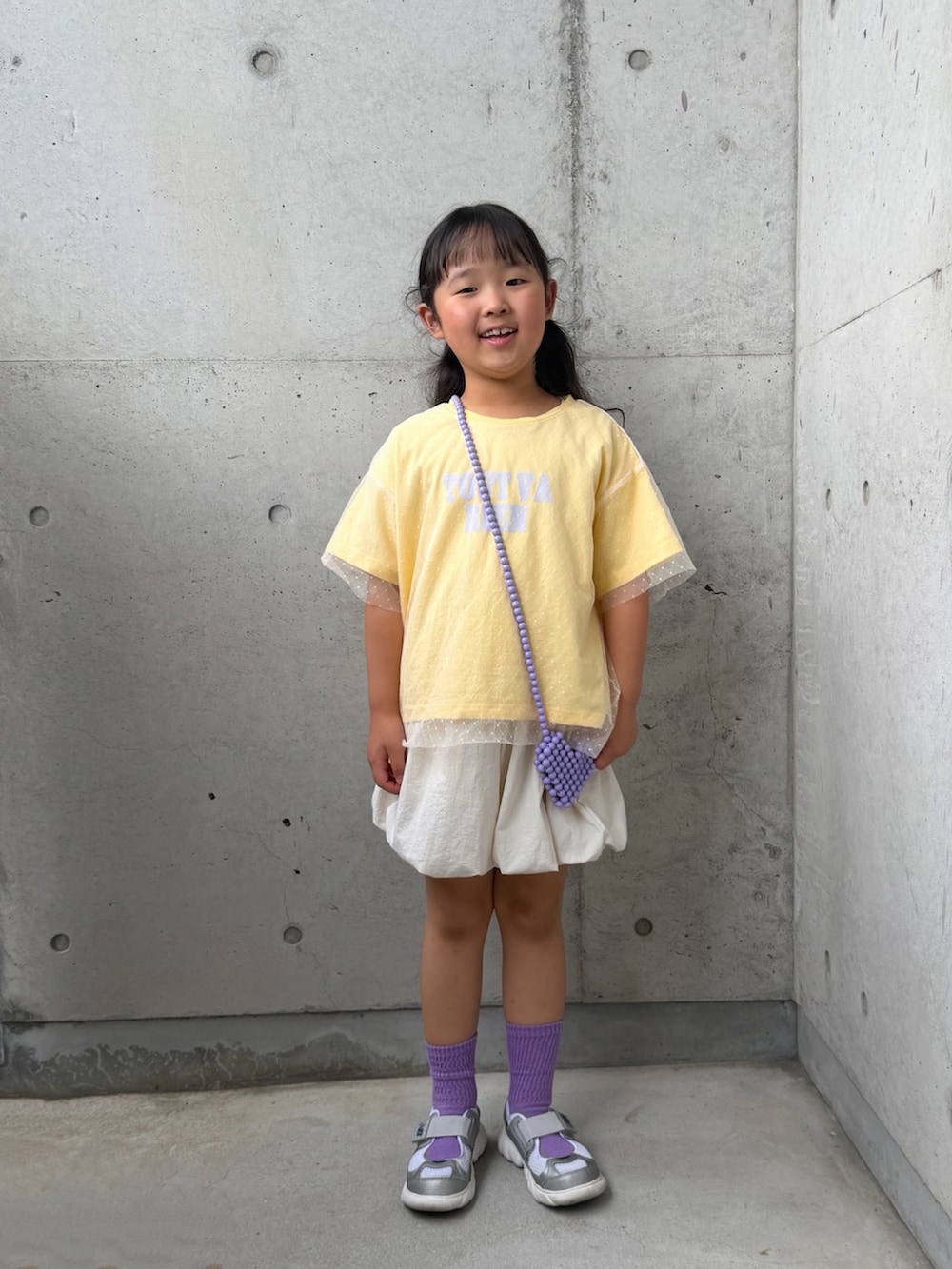 イエロー系のTシャツ/カットソー、ホワイト系のその他パンツ、シルバー系のスニーカーを着用したキッズの春コーディネートの3枚目の写真