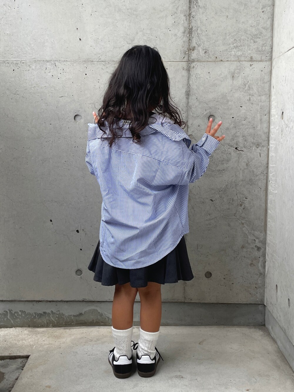 グレー系のスカート、ホワイト系のTシャツ/カットソー、ブラック系のスニーカーを着用したキッズの夏コーディネートの5枚目の写真