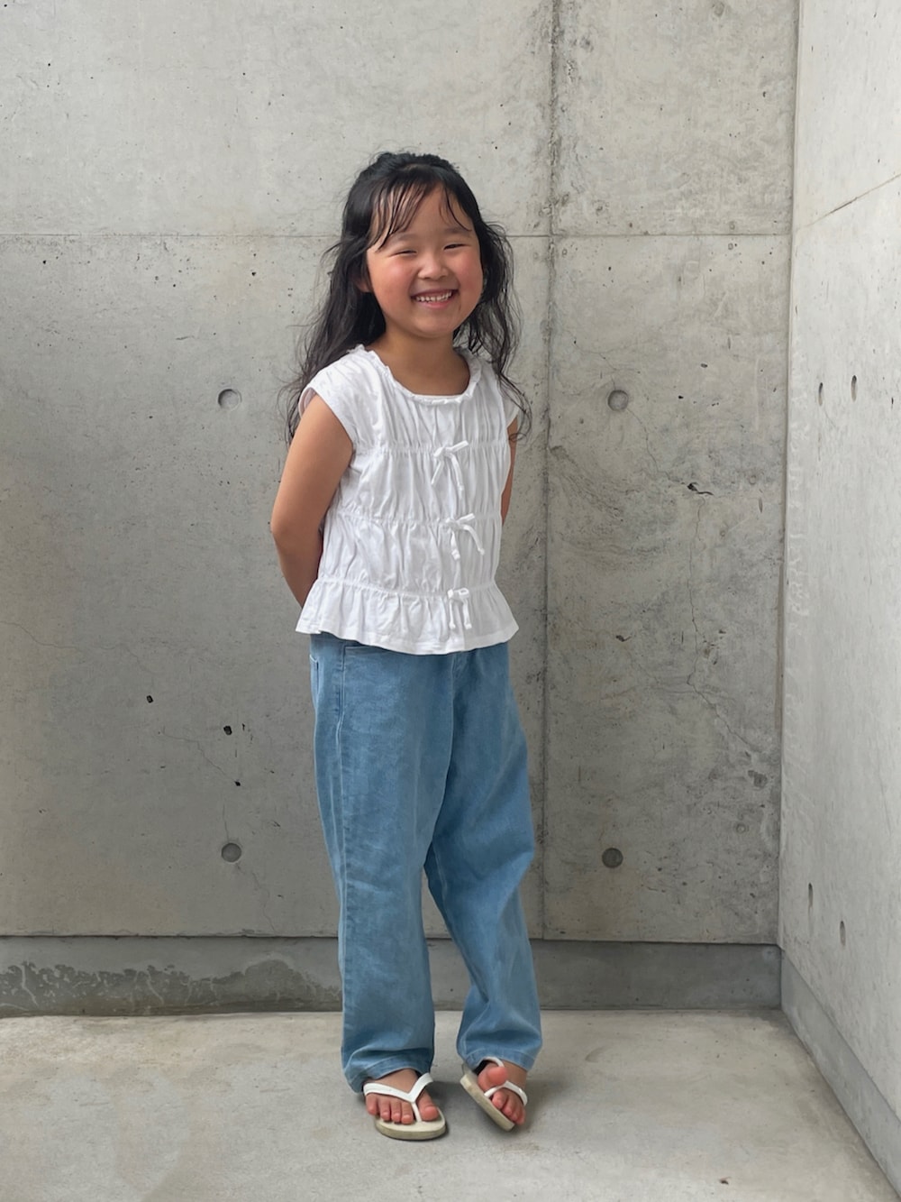 ホワイト系のサンダル、ブルー系のデニムパンツ、ホワイト系のトップスを着用したキッズの夏コーディネートの4枚目の写真