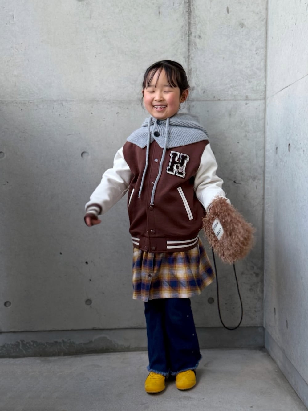 ブルー系のデニムパンツ、イエロー系のワンピース、イエロー系のスニーカーを着用したキッズの冬コーディネートの4枚目の写真