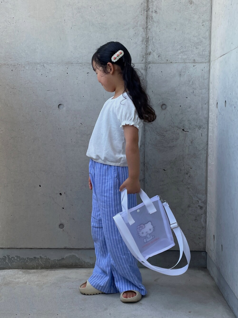 ベージュ系のサンダル、ブラック系のキャミソール、ホワイト系のトップスを着用したキッズの夏コーディネートの2枚目の写真