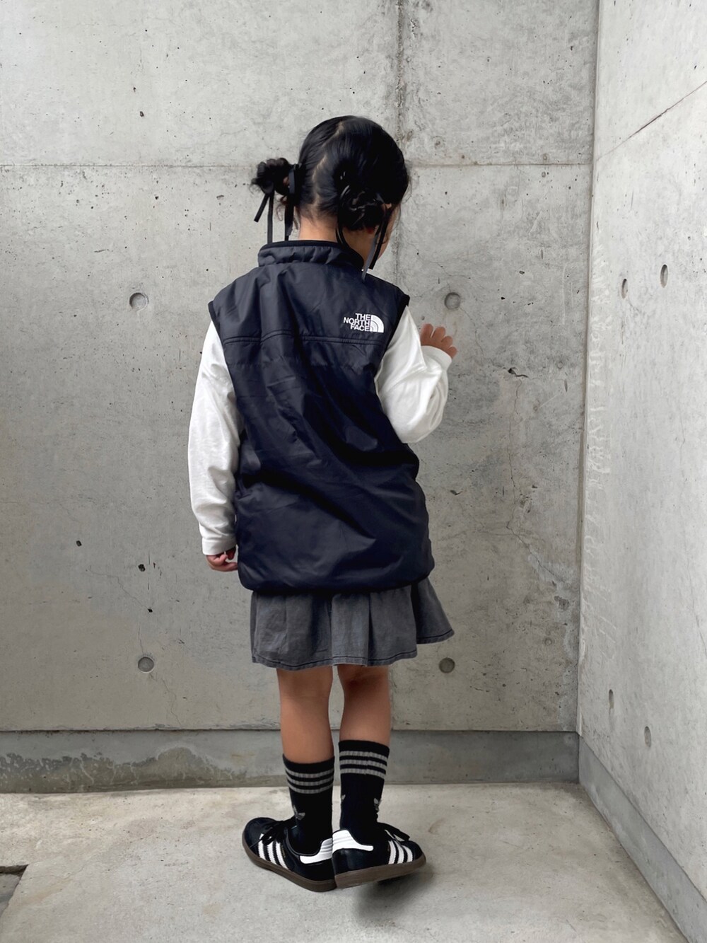 「モノトーン、ベスト、プリーツスカート、キッズコーデ、キッズファッション、ブラックコーデ、シンプルコーデ、ロンT、ロゴT、スニーカー、adidas、THE NORTH FACE、ヘアアレンジ」｜「green label relaxingのTJ 裾タック スカート（ブラックデニム） / キッズ  100cm-130cm（スカート、グレー系）」を使った、ioooさん（キッズ・110cm）の秋コーディネートの2枚目の写真
