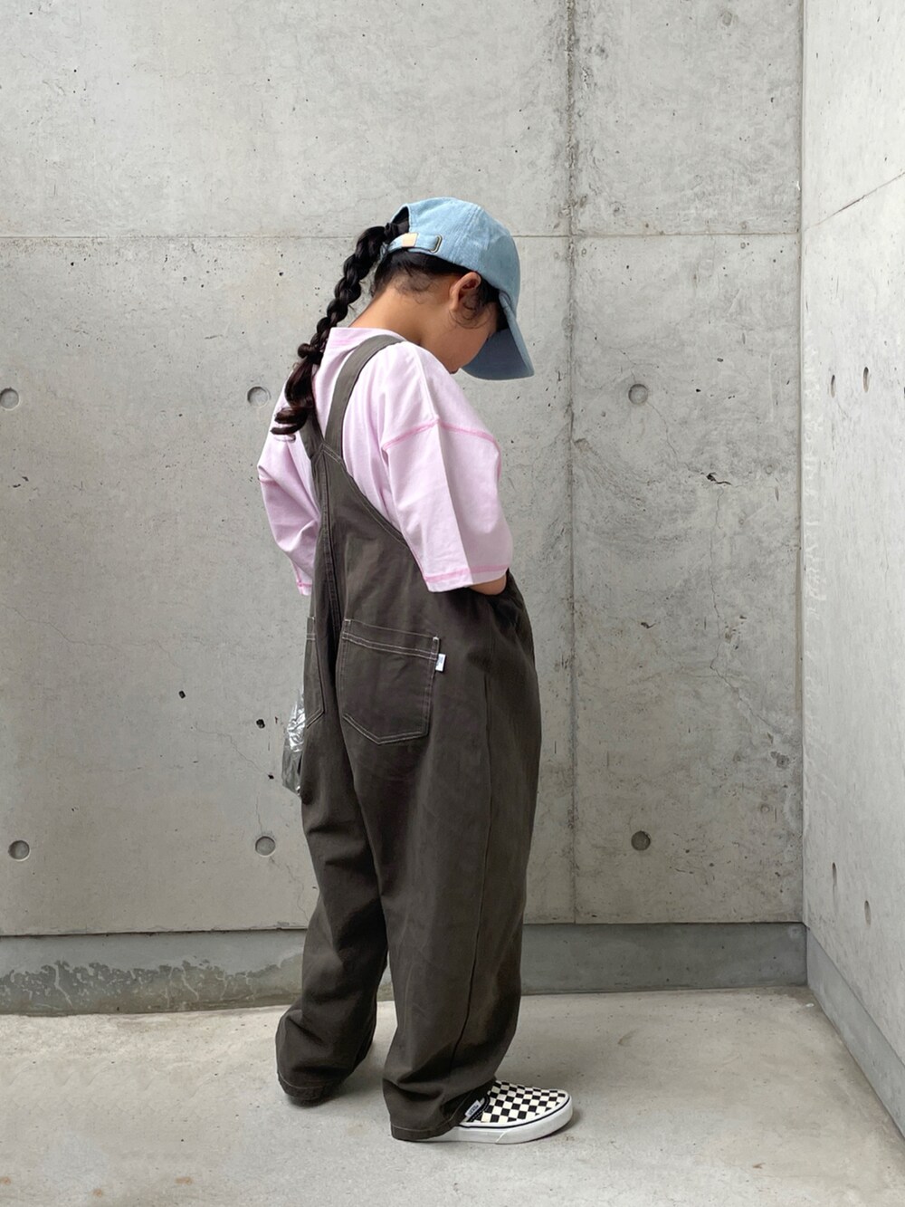 グレー系のサロペット/オーバーオール、ブラック系のスリッポン、パープル系のTシャツ/カットソーを着用したキッズの秋コーディネートの3枚目の写真