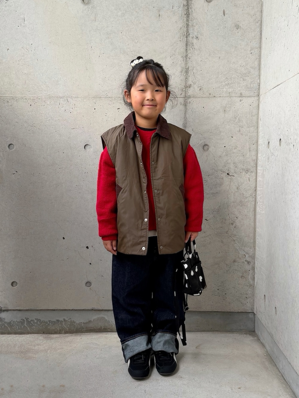 ブラック系のスニーカー、ブラック系のショルダーバッグ、グリーン系のブルゾンを着用したキッズの秋コーディネートの3枚目の写真
