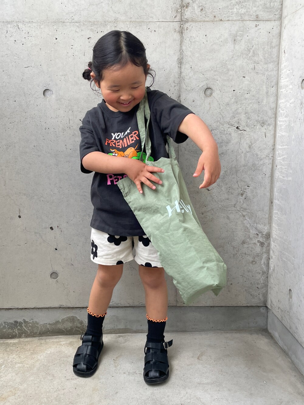 グリーン系のトートバッグ、グレー系のTシャツ/カットソー、ホワイト系のその他パンツを着用したキッズの春コーディネートの3枚目の写真