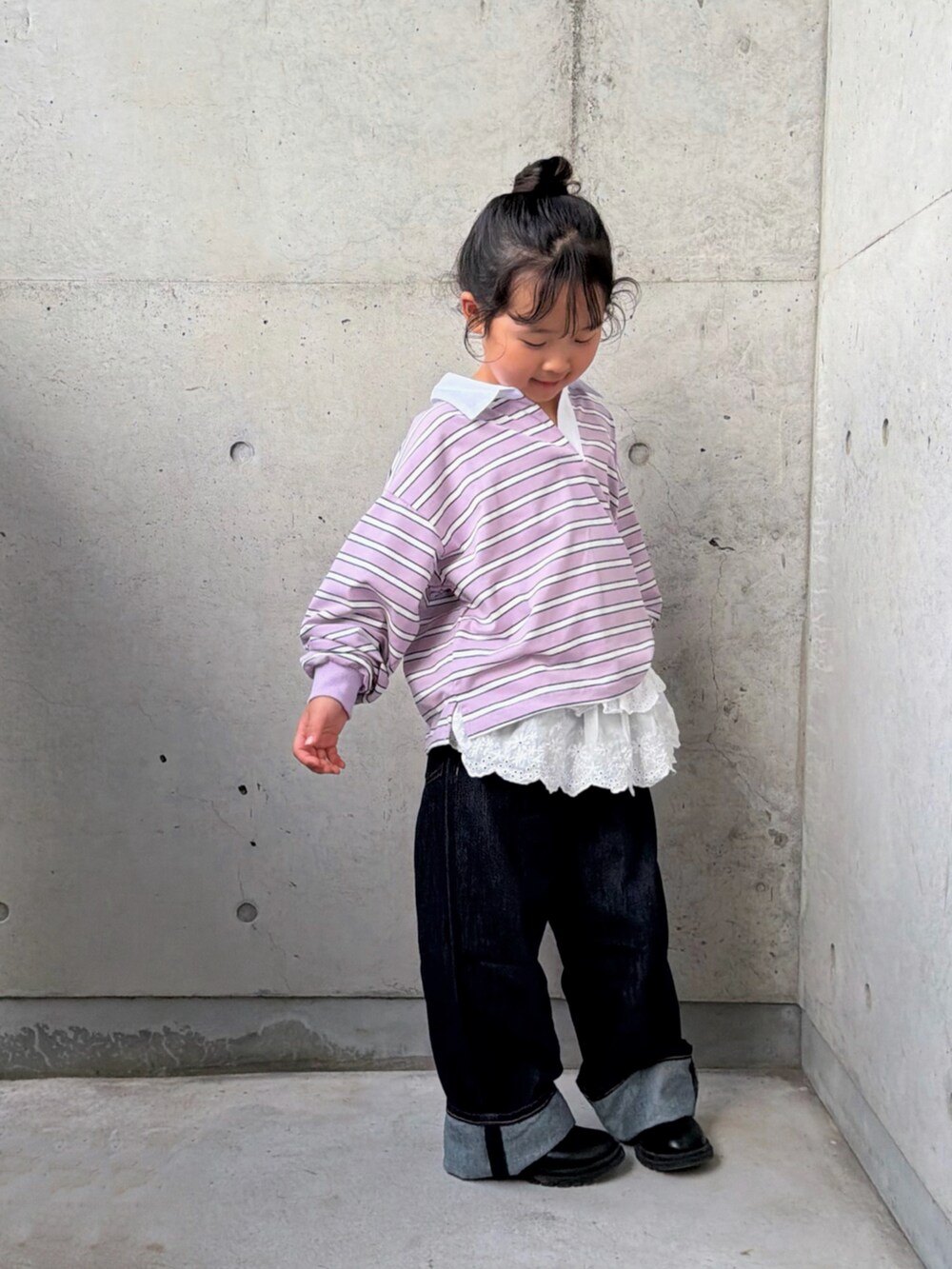 パープル系のポロシャツ、ブラック系のブーツ、ホワイト系のトップスを着用したキッズの秋コーディネートの2枚目の写真